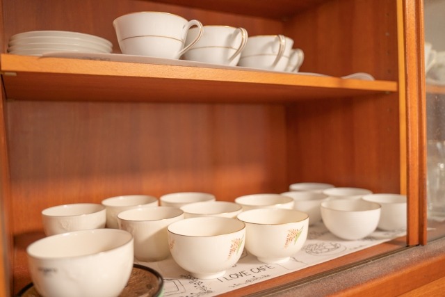 白い食器が並ぶ木製食器棚