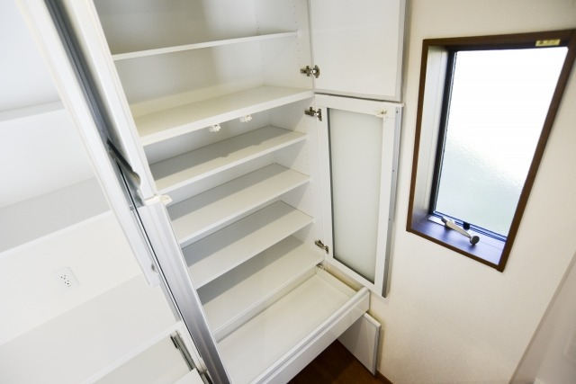 空にして扉を開けた白い食器棚