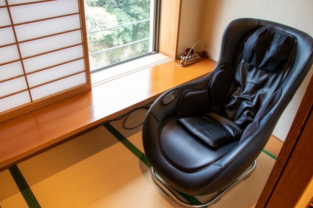 和室に置かれた黒色の大型マッサージチェア