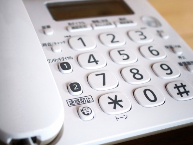 白い固定電話のボタン