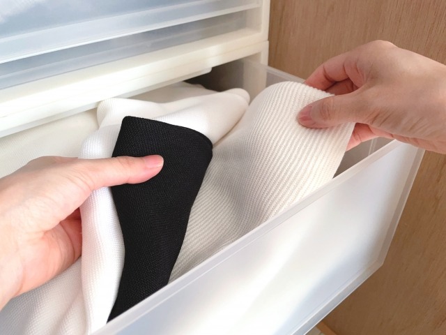 白い衣装ケースから服を取り出す様子