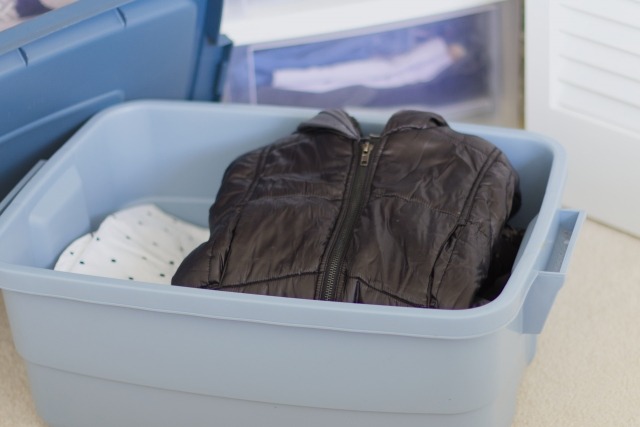 洋服が入った不透明な衣装ケース