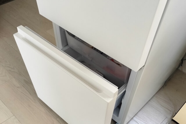 冷凍室を開いた白い冷蔵庫