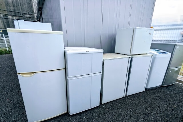 屋外に集積された白い冷蔵庫