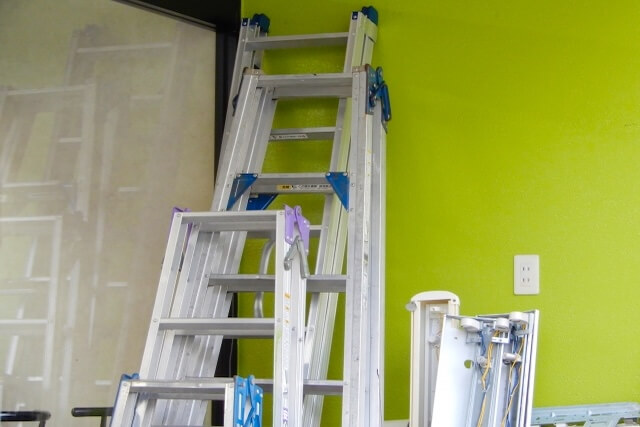 壁に立てかけられた大量の脚立