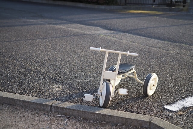 道路に置かれた白い三輪車