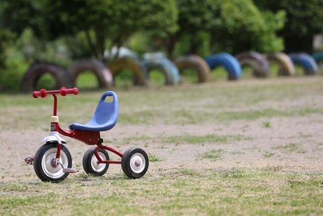 公園に置かれた赤い三輪車