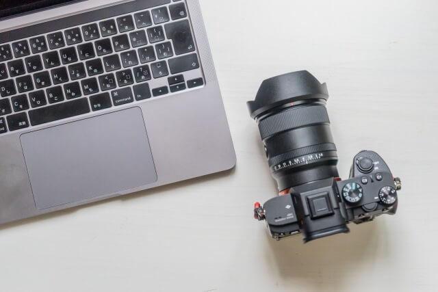ノートパソコンと古い一眼レフカメラ
