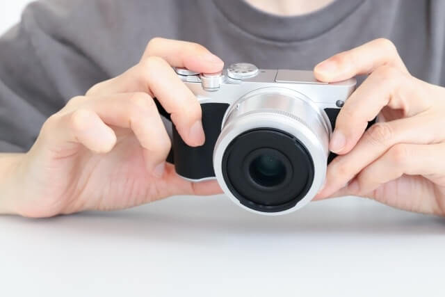 デジタルカメラを構える男性の手元