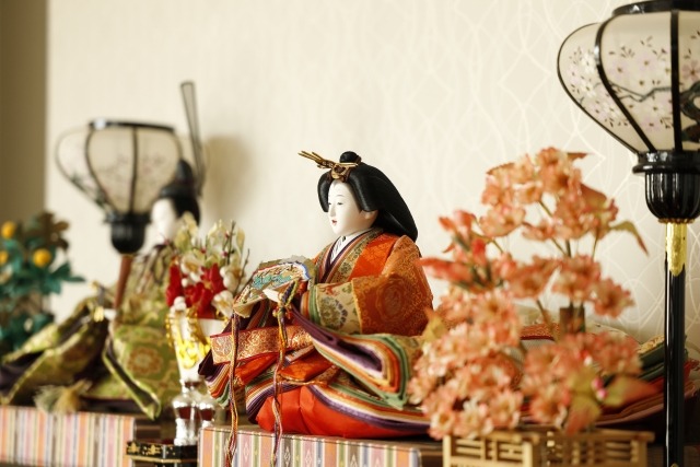 白いスクリーンを背景に飾られた雛人形