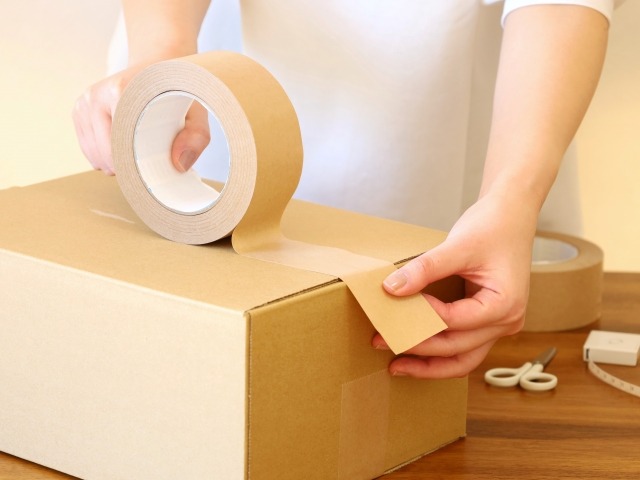 女性が段ボールへ不用品を収納する様子