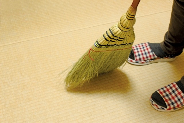 畳をほうきで掃き掃除する様子