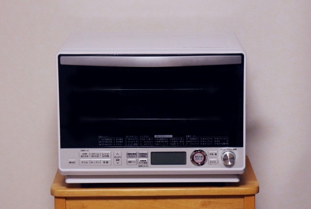 木製チェストに置かれたオーブンレンジ