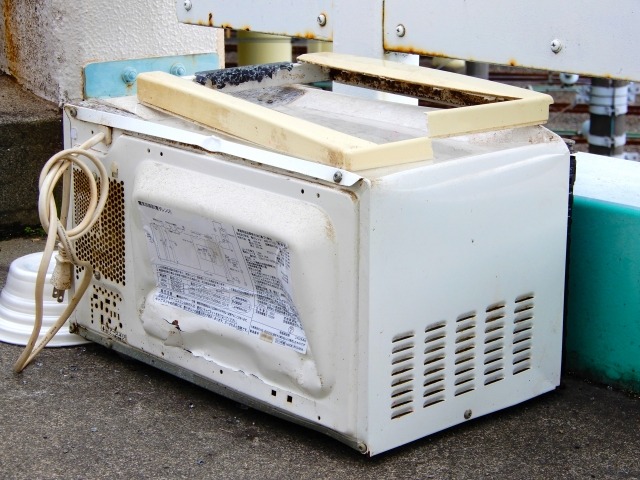 裏側がへこんだ廃棄の電子レンジ