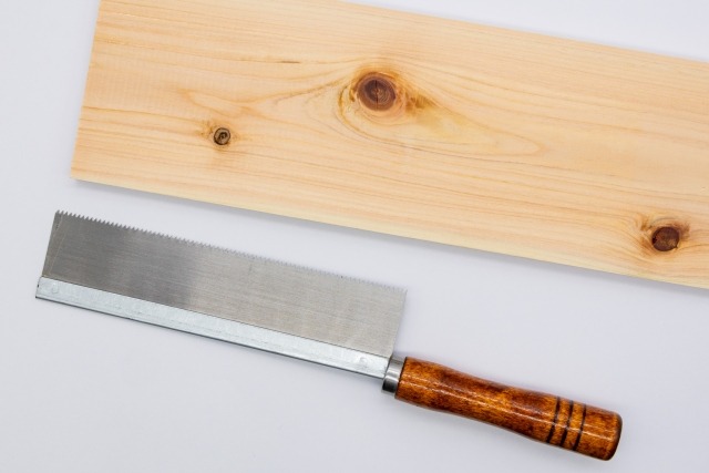 ノコギリが添えられた大判の木材