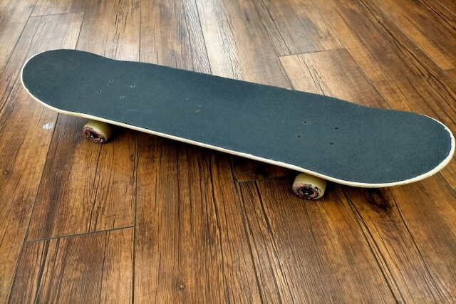 フローリングに置かれた黒いスケートボード