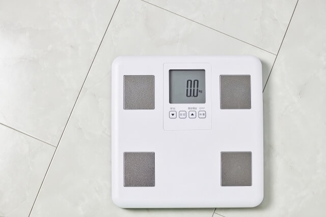 床に置かれた白いデジタル体重計