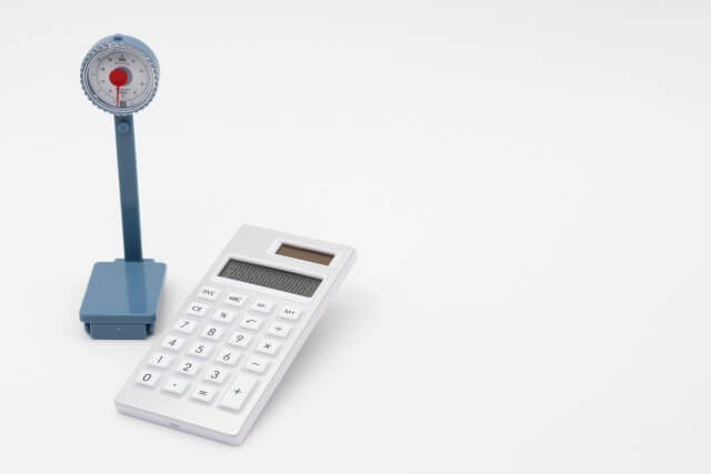 ミニチュアのアナログ体重計と電卓