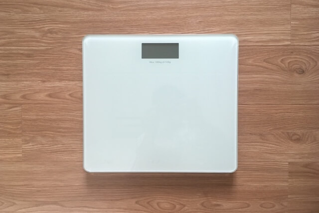木目のフローリングに置かれた体重計